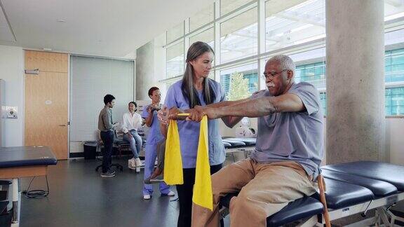 自信的老人在物理治疗过程中使用阻力带