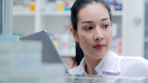 亚洲医生在药店工作她在柜台为顾客研究药品