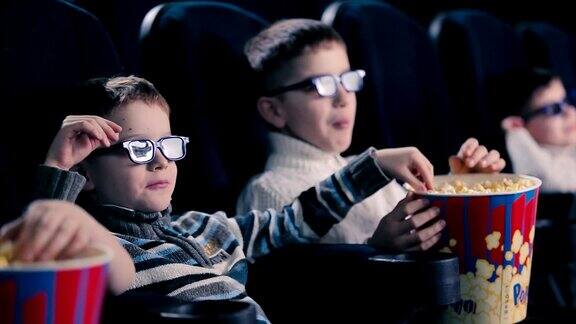 男孩子们正在电影院吃爆米花