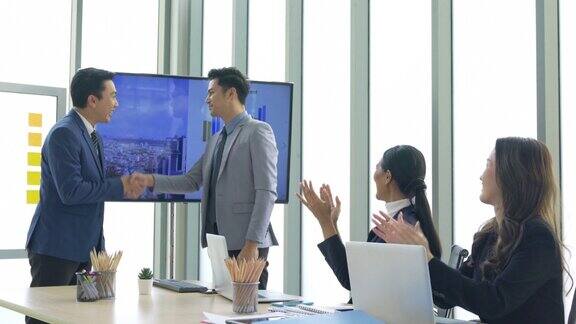业务介绍东南亚商务人士在会议室向同事介绍投资计划并握手