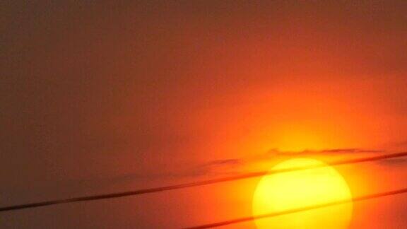 电线后面红色天空上的橙色日落