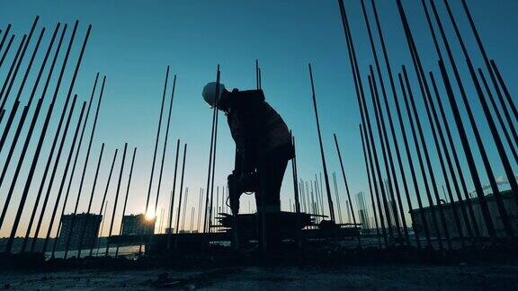一名男性建筑工人正在用手提钻拆除混凝土