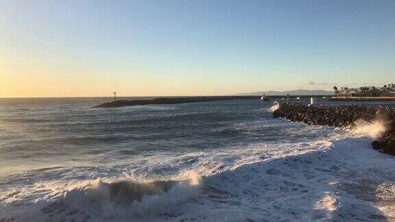 日落时分加利福尼亚雷东多海滩上汹涌的海水撞击着岩石