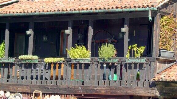 一座古老的黑色木屋阳台上有鲜花