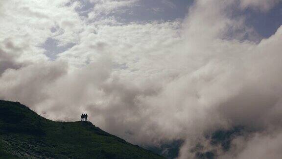 这四个人站在一座有着美丽云景的山上