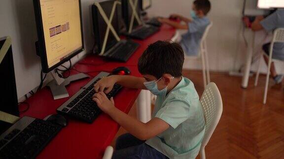 在私立学校课堂上使用电脑的男孩