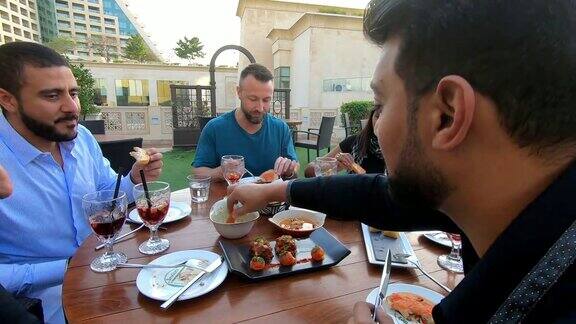 一群多民族的阿拉伯朋友在迪拜的一家餐馆共进午餐