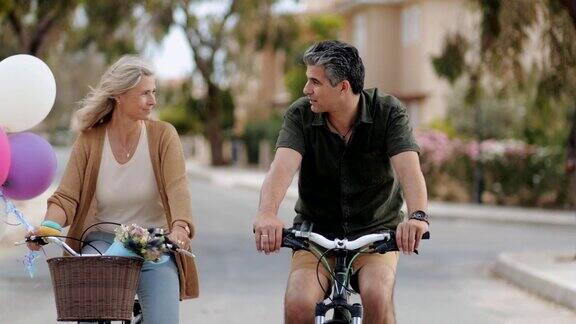 快乐的成熟夫妇在浪漫的约会中一起骑自行车