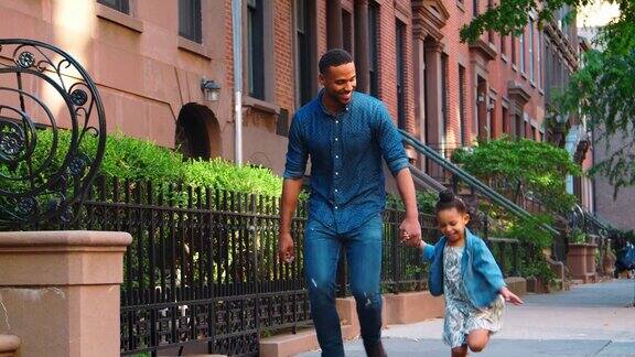 父亲和女儿手牵着手走在街上