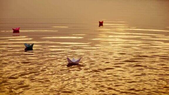 在日落时在水上漂浮纸船