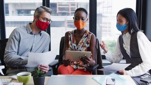现代办公室里形形色色的同事戴着口罩一起讨论