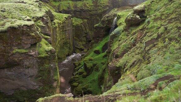 慢镜头美丽的河流在绿色峡谷与小瀑布在冰岛