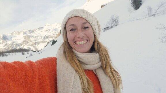 女人在瑞士旅行在冬季拍摄自拍照视频肖像在山区在冬季仙境的乐趣