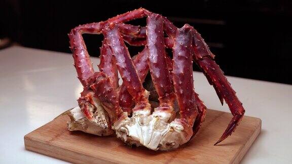 烹饪有机阿拉斯加帝王蟹腿阿拉斯加帝王蟹放在木盘上白色背景