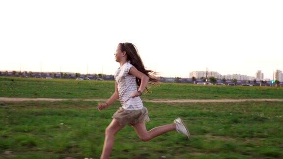 夏天的城市草坪上快乐的小女孩在草地上奔跑