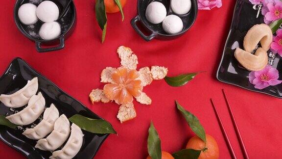 中国新年食品饮料静止的生命食物和饮料蒸饺汤圆幸运饼干在黑盘子和红色的背景副本的空间