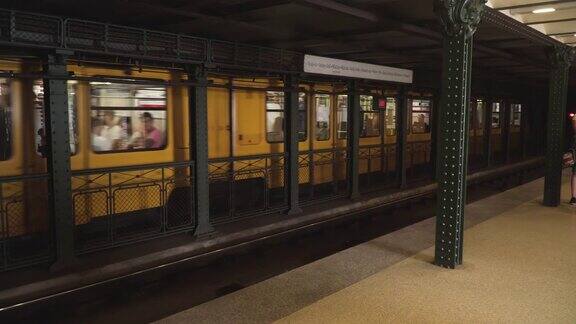 经典的地铁站台全景图:在匈牙利布达佩斯的夏日周末游客们乘坐地铁上的黄色有轨电车体验旅程和旅行目的地