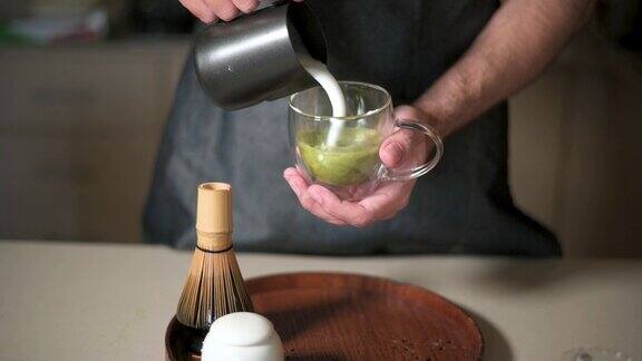 男人用牛奶泡制作抹茶绿茶拿铁