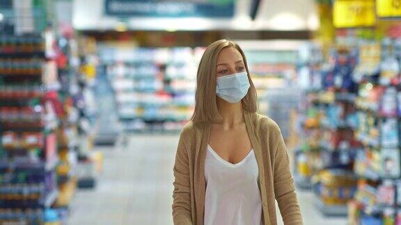 一个戴着医用防护面具的女人走过超市购买者在新冠肺炎大流行期间购买物品在新冠肺炎期间采取的防护措施4kProRes