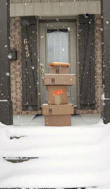 冬天暴风雪时堆放在门外的快递盒子