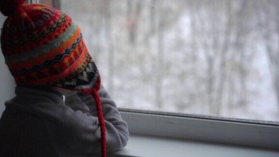 一个小男孩在大雪中望着窗外等待着圣诞节的到来Slowmotion拍摄
