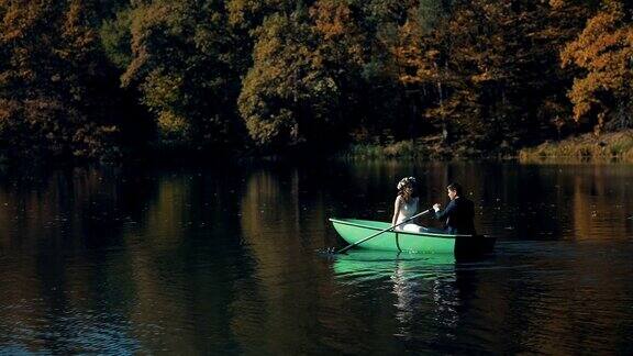 年轻的新婚夫妇在美丽的湖面上游泳