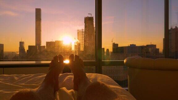 躺在床上看着太阳从现代摩天大楼后面升起