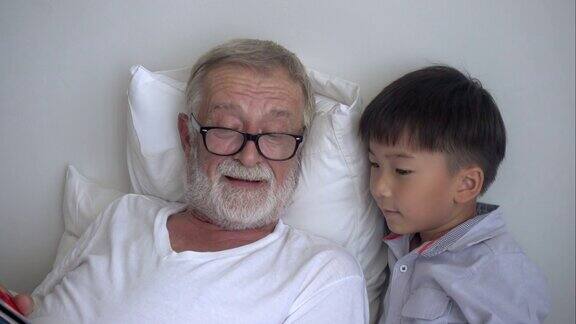 在敬老院的床上快乐的老爷爷给孙子讲玩的故事