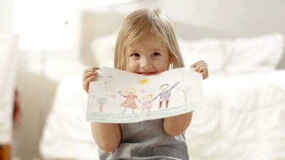 可爱的小女孩展示她的家庭图画