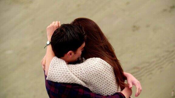 年轻情侣在海滩上拥抱嬉戏调情
