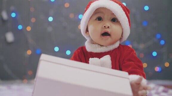小女孩穿着圣诞老人的服装坐在家里的地板上过圣诞节