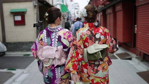 年轻女性朋友穿着和服在日本传统城镇散步的后视镜视频