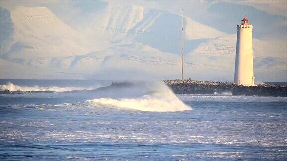 冬季阳光明媚的冰岛雷克雅未克汹涌的海浪卷进格罗塔湾