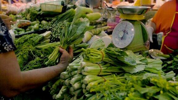 在市场上买新鲜蔬菜的女人