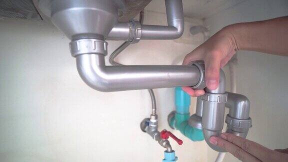 工人正在修理厨房排水系统的问题