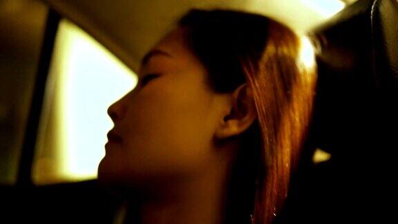 年轻的亚洲女人试着晚上睡在出租车里