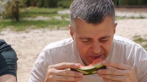 那个人正在吃一个多汁的西瓜炎热的夏天美味的水果