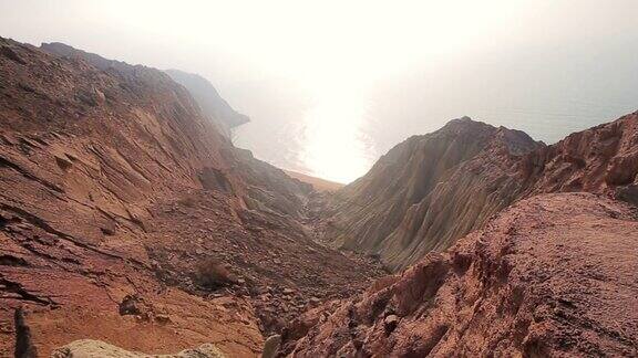美丽的彩色沙漠岩石山脉全景与波斯湾霍尔木兹海峡岛伊朗