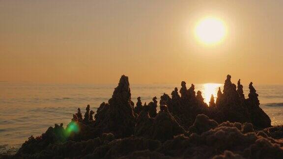 夕阳照在海边的沙堡上