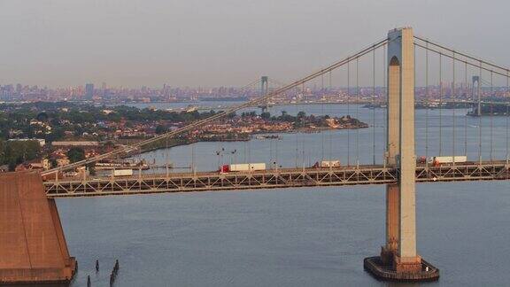 鸟瞰图的Throgs颈桥和白石桥随着东河与曼哈顿在日出时的背景的一个遥远的观点无人机视频镜头与全景相机运动