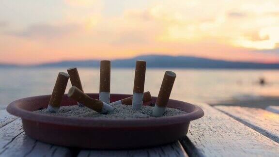 海上烟灰缸里的烟头美丽的希腊日落