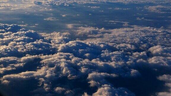 从飞机窗口鸟瞰图上的云与蓝天从飞机窗口望向蓝天白云乘飞机旅行