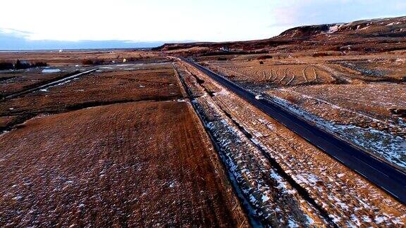 鸟瞰被白雪包围的道路一辆白色汽车在夕阳下-冰岛