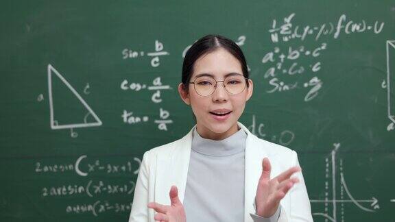 年轻的亚洲女教师与学生在摄像机视频会议上讲话女教师在课堂上培训数学黑板在线课程