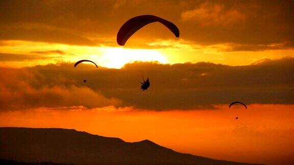 日落时滑翔伞的剪影