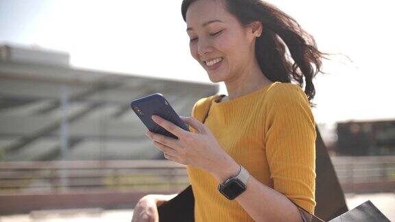 亚洲女性在现代办公室里使用智能手机