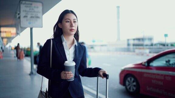 亚洲女商人在城市街道上匆忙等待优步出租车