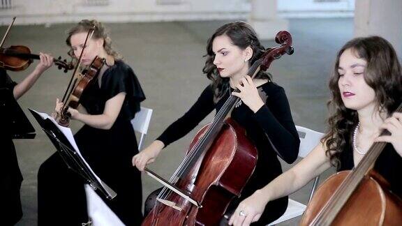 在管弦乐队中女孩们演奏小提琴、大提琴和小提琴