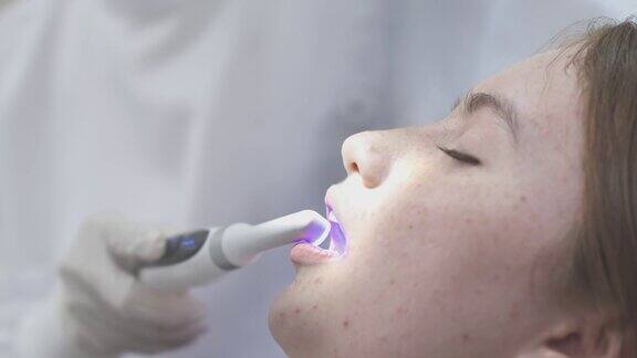 十几岁的女孩在牙医那里检查牙齿可爱的女孩坐在牙科椅上接受牙科治疗