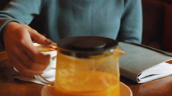 一名女子在餐厅倒橙茶的镜头